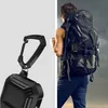 A split image showing a carabiner clip with an AirPods case attached on the left, and a person with a backpack on the right. Voir les images du produit
