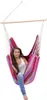 A young woman sits in a colorful striped hammock chair. Anteprima dell’immagine prodotto