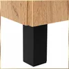 A close-up view of the corner of a piece of furniture, showing the wood grain texture of the top surface and a black square leg. Podgląd zdjęcia produktu
