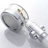 A close-up studio shot of a chrome and clear plastic shower head with a gold-colored internal component. Produktbild-Vorschau