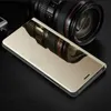 A gold flip case for a smartphone is displayed on a black surface, with a camera lens reflected on its surface. Produktbild-Vorschau