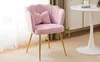A pink velvet chair with gold legs is placed in a room with a white table and curtains. Produktbild-Vorschau