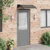 A door with an awning above it, set against a brick wall. Náhled obrázku produktu