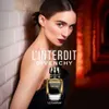 A woman is leaning against a tiled wall, with a bottle of Givenchy L'Interdit perfume in the foreground. Podgląd zdjęcia produktu