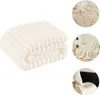 A collage of images showing a folded beige fleece blanket and the blanket draped on a bed and a couch. Produktbild-Vorschau