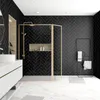 A modern bathroom with a gold-framed shower enclosure, black herringbone tiles, and marble flooring. Produktbild-Vorschau