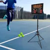 A person playing tennis on a court with a digital scoreboard in the background. Podgląd zdjęcia produktu