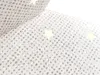A close-up view of a white fabric with silver glitter and small star shapes. Podgląd zdjęcia produktu