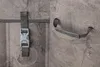 Close-up of a grey textured surface with two different attachment mechanisms: one with a buckle and suction cup, and another with a handle and two suction cups. Produktbild-Vorschau