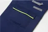 A close-up view of a dark blue work garment, likely trousers or overalls, showing a pocket with a yellow trim and reflective gray strips on another part of the garment. Produktbild-Vorschau
