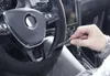 A person's hand is shown plugging a cable into a car's steering wheel. Podgląd zdjęcia produktu