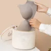 A person is placing a gray bra into a beige mesh laundry bag. Produktbild-Vorschau