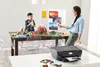 A mother and son are working on a school project involving a volcano model, with a printer in the foreground. Voir les images du produit