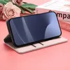 A pink flip case for a smartphone is shown in a studio setting with decorative flowers and books in the background. Produktbild-Vorschau