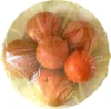 A top-down view of several tomatoes covered in plastic wrap, arranged in a bowl. Produktbild-Vorschau