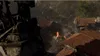 An aerial view of a destroyed village with smoke and fire. Produktbild-Vorschau