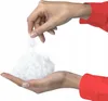 Two hands are shown, one holding a pile of white fluffy material, and the other hand is dropping more of the material onto the pile. Produktbild-Vorschau