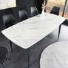 A modern dining room setting with a white marble-look table and black chairs. Produktbild-Vorschau