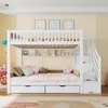 A white bunk bed with stairs, shelves, and drawers in a child's bedroom. Produktbild-Vorschau