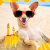 A dog wearing sunglasses on a beach with toy chickens. Náhľad obrázku produktu