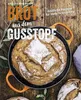 A rustic overhead shot of a loaf of bread in a cast iron pot, surrounded by olive branches and other loaves of bread on a wooden surface. Produktbild-Vorschau