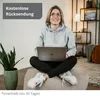 A woman is sitting on the floor with a laptop on her lap, looking up and smiling. There is a plant in a pot to her left. Produktbild-Vorschau