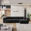 A modern living room with a large black sectional sofa, a wooden bookshelf with stairs in the background, and a large potted plant. Produktbild-Vorschau