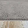 A close-up view of a gray, high-pile rug on a wooden floor. Produktbild-Vorschau