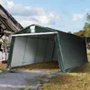 A dark green carport tent is set up outdoors on a gravel and grass area, next to a building. Anteprima dell’immagine prodotto