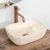 A beige rectangular vessel sink with a copper faucet is shown on a wooden countertop. Podgląd zdjęcia produktu