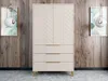 A sandbeige wardrobe with gold metal handles and legs, set against a wood-paneled wall with two framed artworks and pendant lights. Náhled obrázku produktu