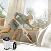 A woman is vacuuming a sofa in a bright, sunlit room. Produktbild-Vorschau