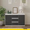 A sideboard with drawers and doors, decorated with a plant and bottles. Náhľad obrázku produktu