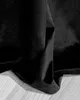A close-up shot of black velvet fabric draped over a light-colored wooden floor. Podgląd zdjęcia produktu