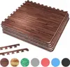 A stack of interlocking foam floor mats with a dark wood grain pattern, along with several smaller edge pieces and circular swatches of different mat colors and textures. Náhľad obrázku produktu
