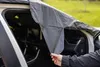 A person is holding a car windshield cover inside a car. Náhled obrázku produktu