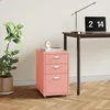 A pink filing cabinet is placed next to a desk with a laptop and a lamp. Náhled obrázku produktu
