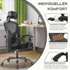 A black ergonomic office chair is shown in a room with a desk and window. Voir les images du produit