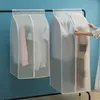 Two transparent garment bags hanging on a rack, one with a person reaching into it. Produktbild-Vorschau