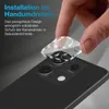 A hand is shown applying a clear camera lens protector to a smartphone. Produktbild-Vorschau