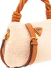 Close-up of a beige fuzzy handbag with brown leather accents and a gold Guess logo. Produktbild-Vorschau
