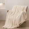 A cream-colored sherpa blanket draped over a chair. Podgląd zdjęcia produktu
