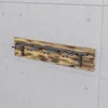 A wooden ski rack with metal hooks mounted on a concrete wall. Anteprima dell’immagine prodotto