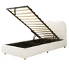 A white upholstered bed frame with the mattress support mechanism open, revealing the storage space underneath. The bed has a heart-shaped headboard and wooden legs. Anteprima dell’immagine prodotto