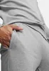A person's hand is in the pocket of gray sweatpants. Anteprima dell’immagine prodotto
