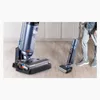 A person is using a floor cleaner in a room. Produktbild-Vorschau
