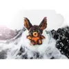 A plush bat toy sitting in a clear bubble surrounded by white fluffy material and black confetti. Produktbild-Vorschau