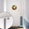 A Christmas wreath hangs on a white door, with a close-up inset showing a door hook. Produktbild-Vorschau