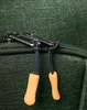 A close-up view of two zipper pulls on a green fabric bag. Náhled obrázku produktu