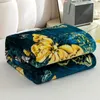 A folded blanket with a butterfly pattern is placed on a surface. Produktbild-Vorschau